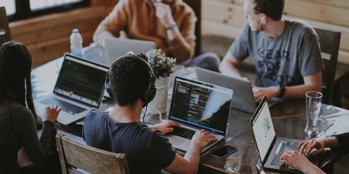 People working together with their MacBooks